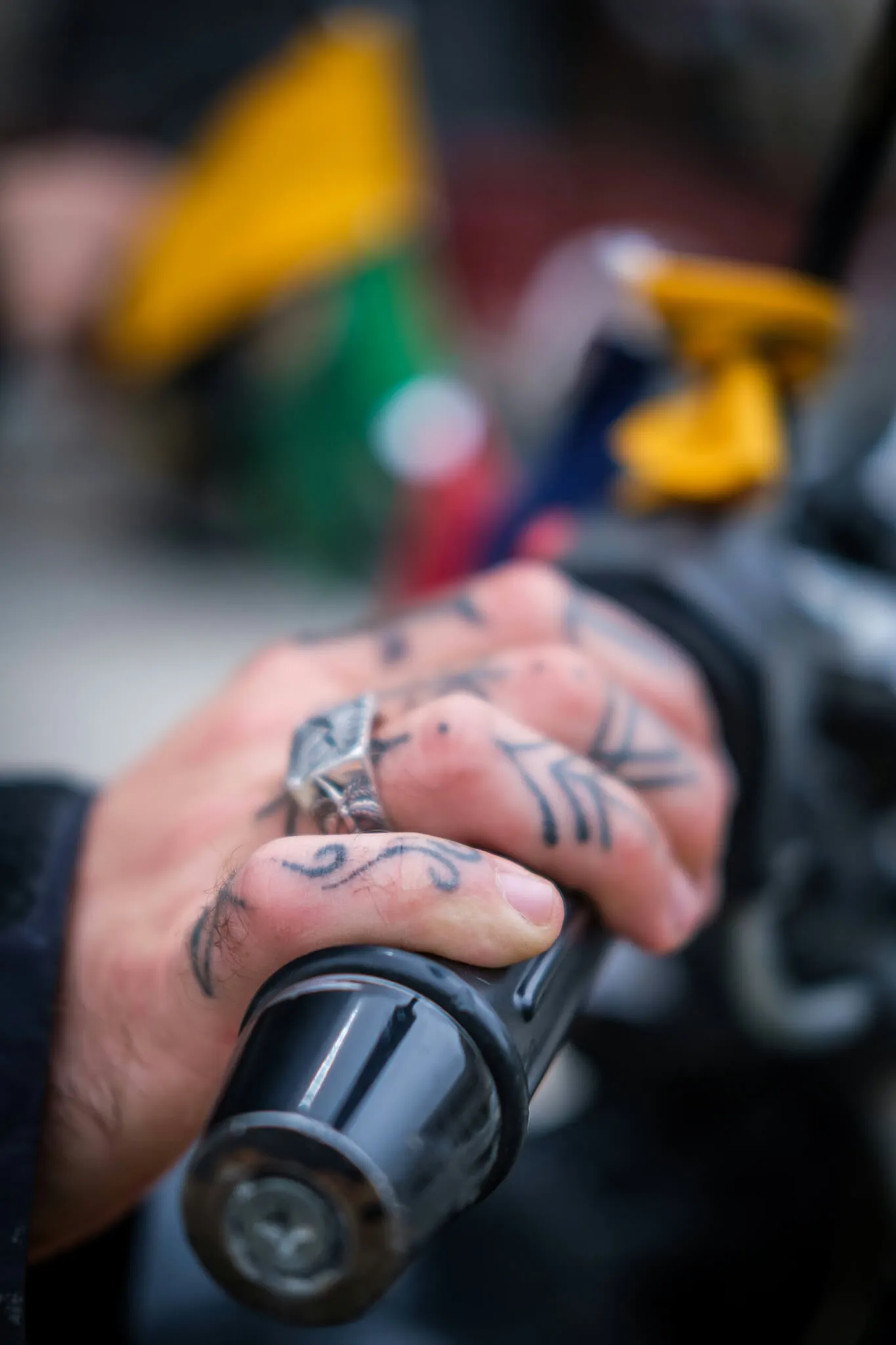 Een close-up foto van Will's hand met tatoeages op het gas van een motorfiets