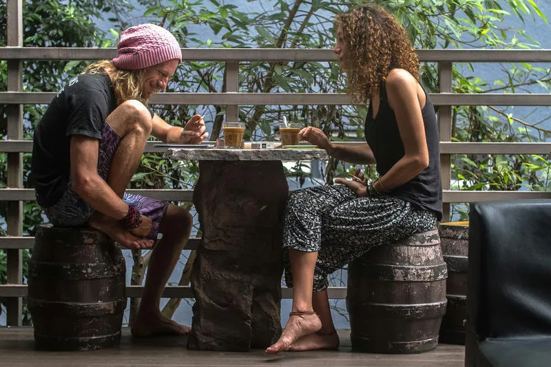 Step Inn Guest House Best Cheap Hostels in Kuala Lumpur. Two travellers sitting at a table outside drinking coffee