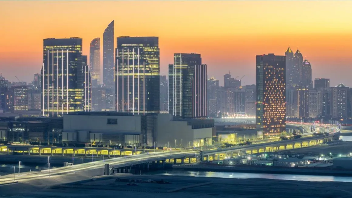 Al Maryah and Al Reem Islands at sunset with lit up sky scrapers.