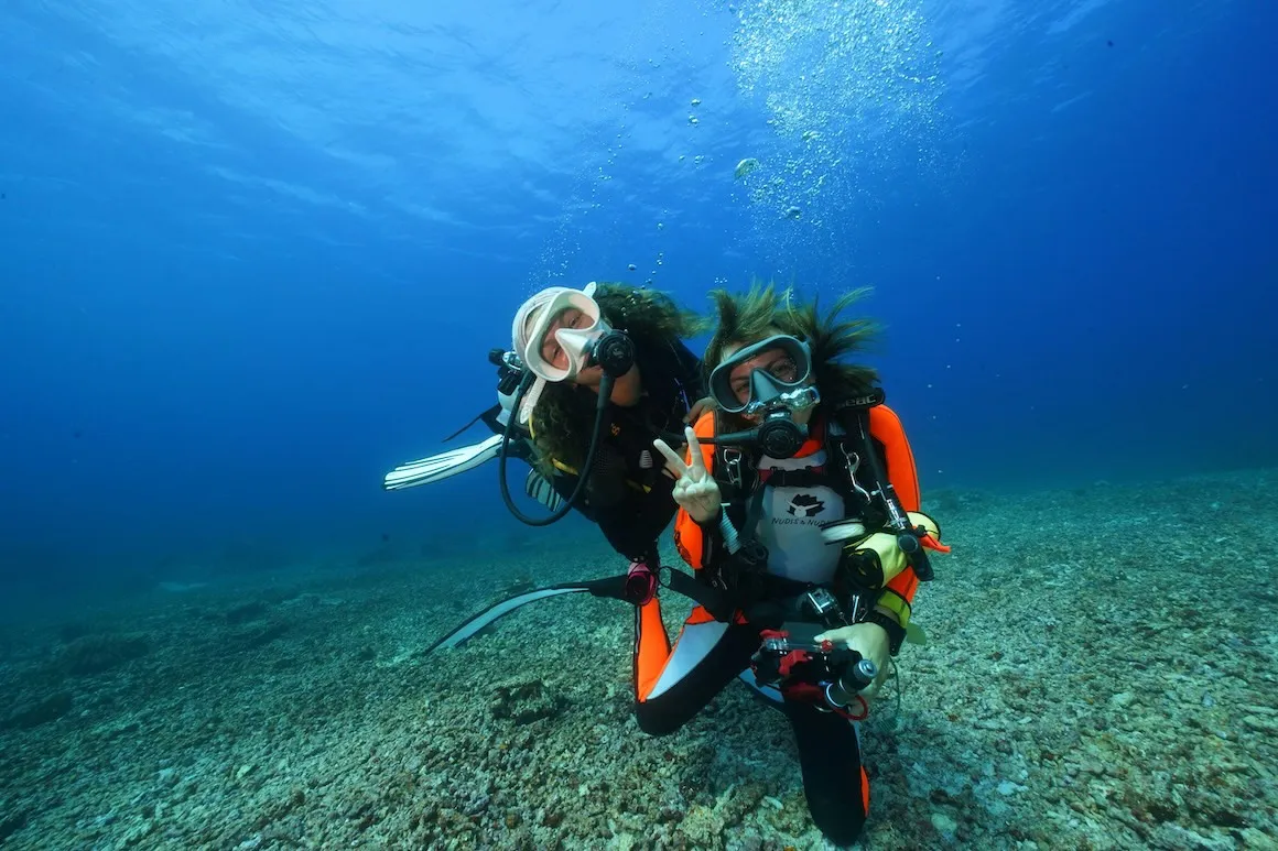 Two girls scuba diving in the crystal clear waters of Bali.