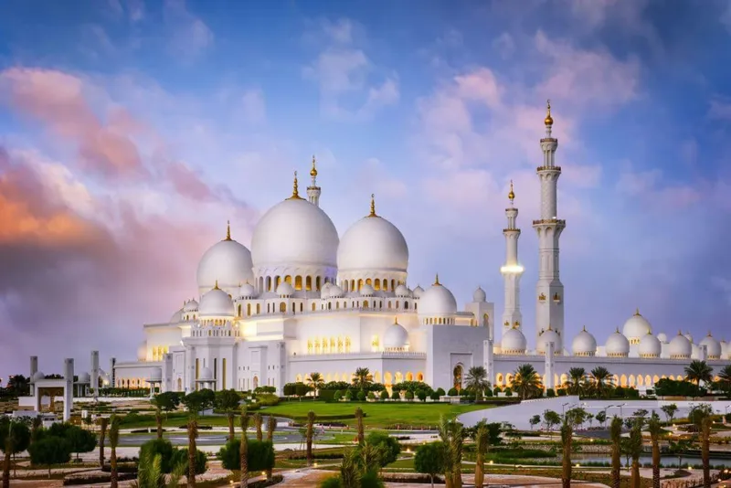 sheikh zayed grand mosque iwth a cotton candy sunset sky in the background