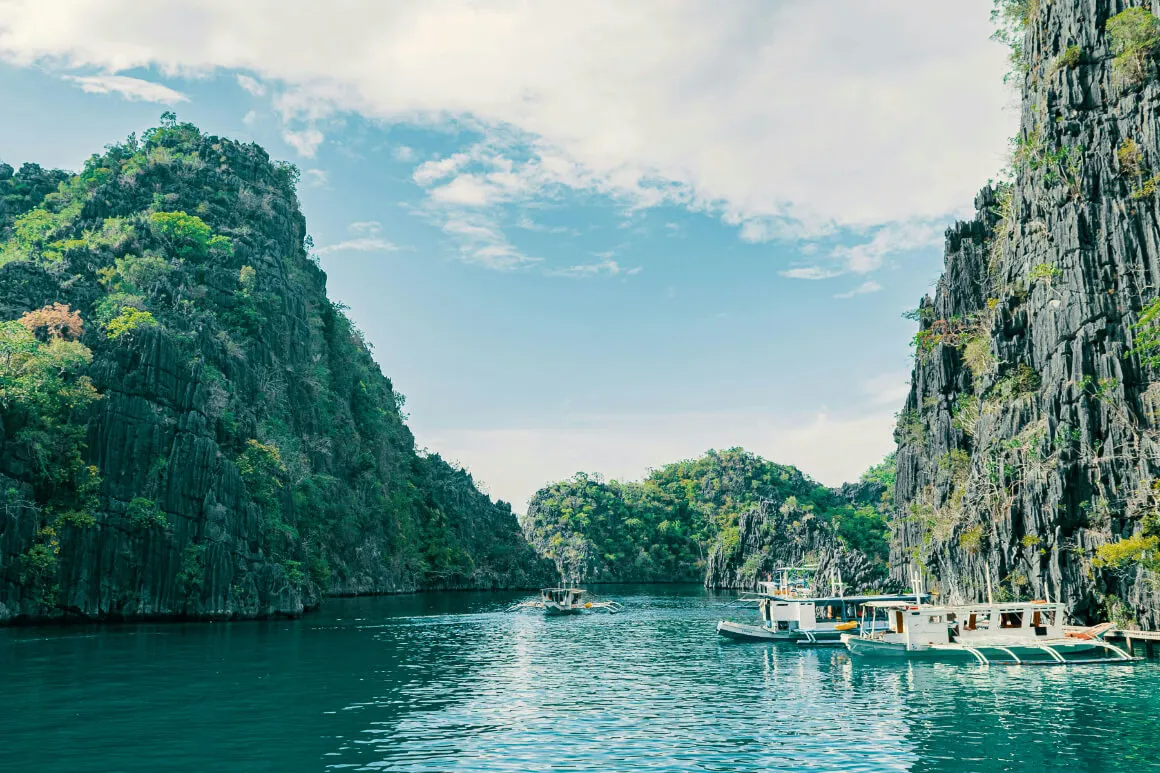 local boats docked near limestome cliffs at the Kayangan Lake, Coron