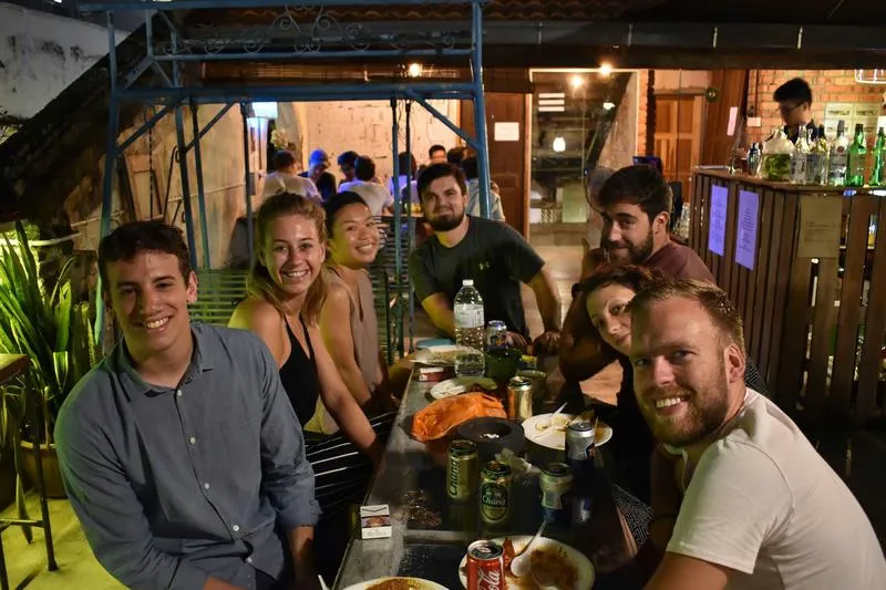 Mingle Best Hostel for Solo Traveller in Kuala Lumpur. Friends in the outside common area sharing a meal and drinks