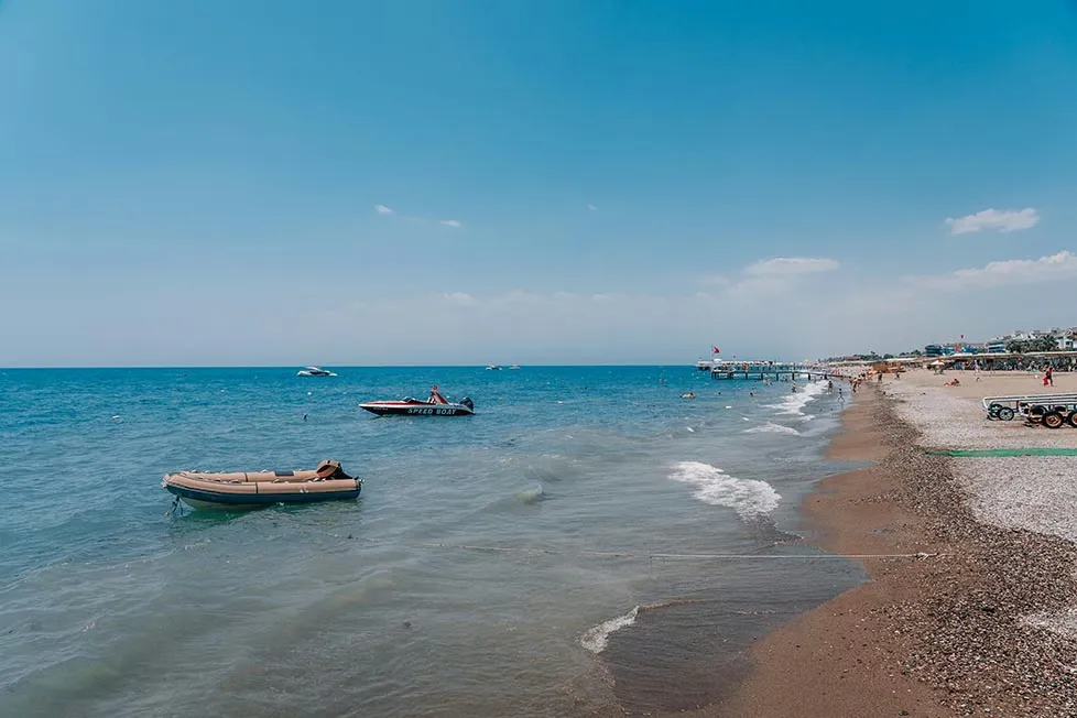 Boats sitting just off the beach in the sea near Antalya