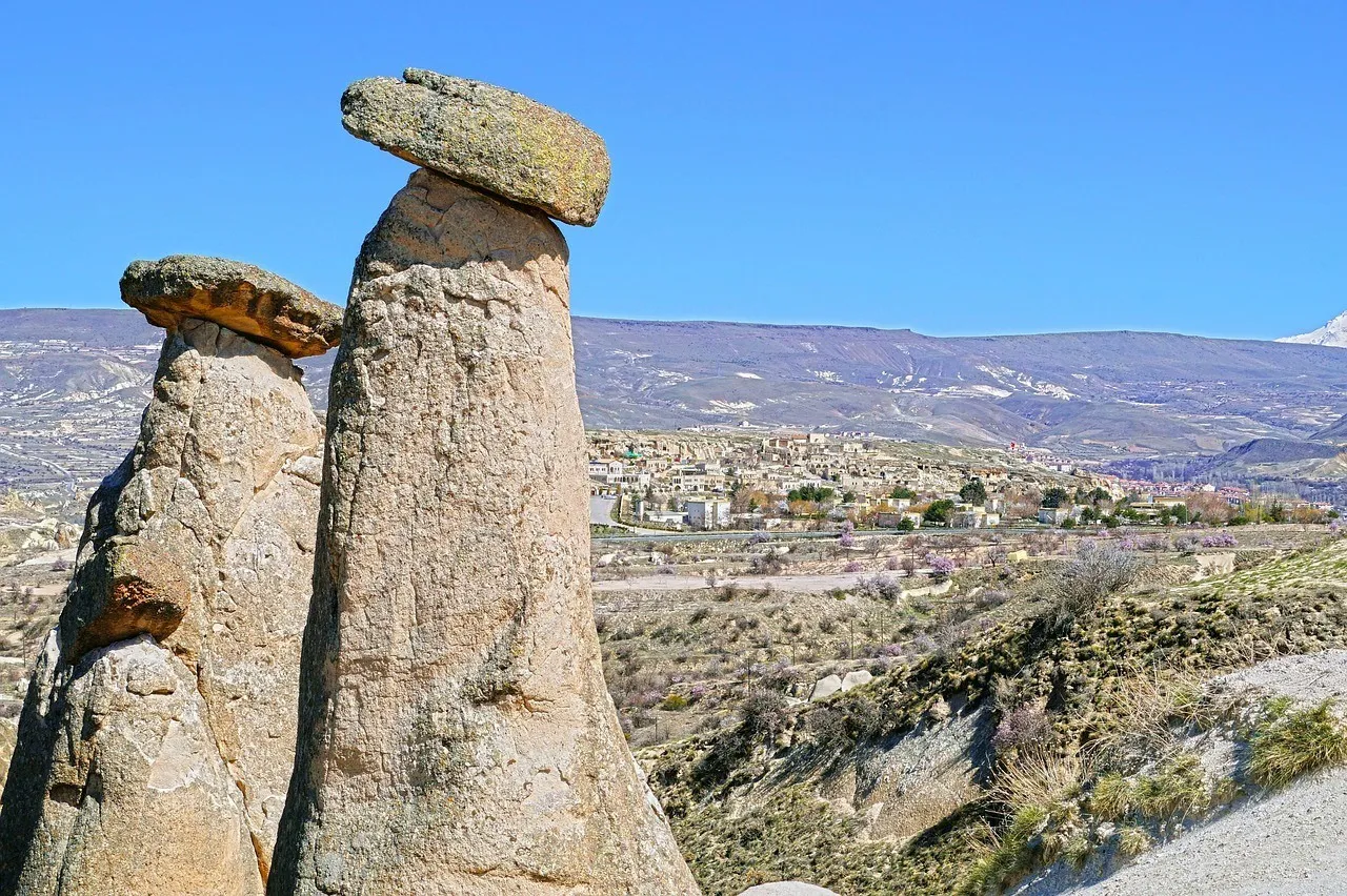 Urgup, Cappadocia with rock formations in the foreground and the town in the valley behind with clear blue skies
