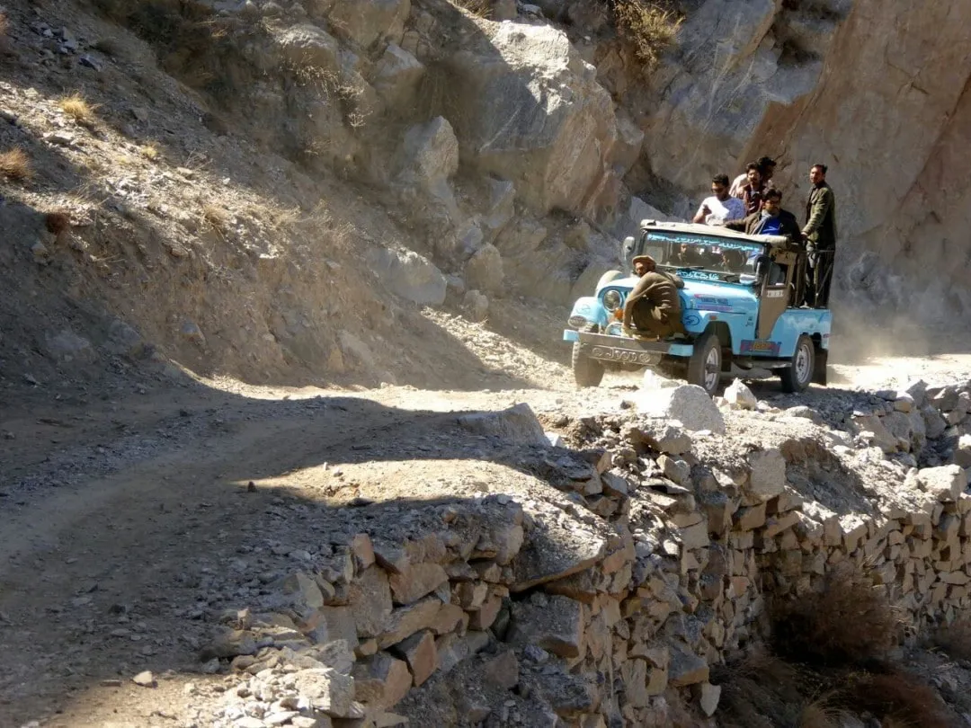 a group of man riding through mountains in Pakistan