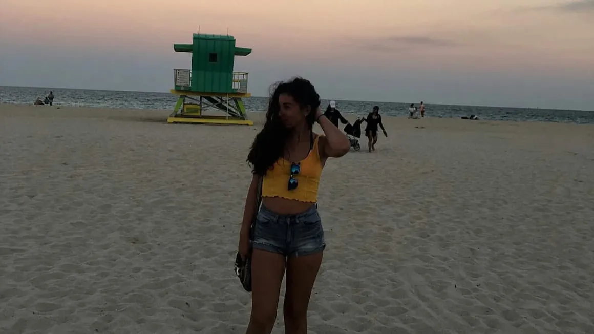 a girl at south beach in miami, florida at the sun sets on the ocean