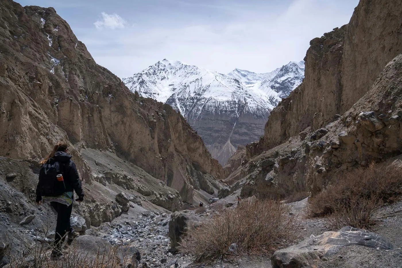 a girl walking through a canyon in shimshal valley in pakistan